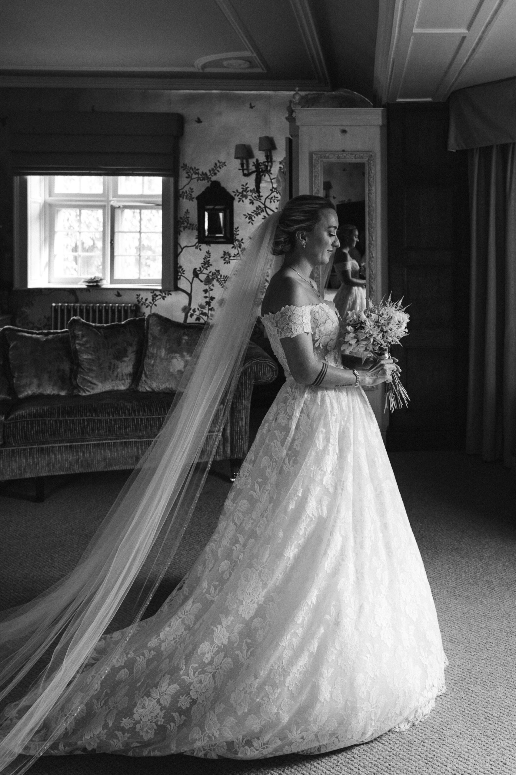 A black-and-white fine art image of Emily dressed and ready for her wedding day.